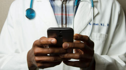 Image of physician looking at smart phone