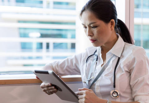 Image of physician reading a tablet